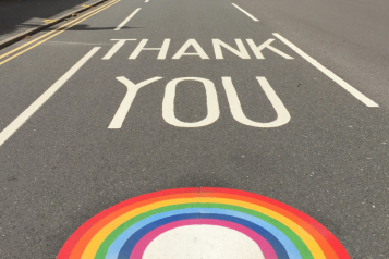 Road with "thank you" written on and NHS rainbow