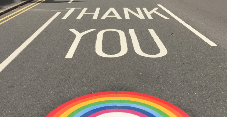 Road with "thank you" written on and NHS rainbow