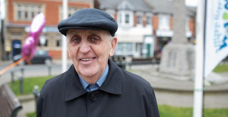 Older man facing front smiling at camera