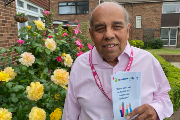 Man facing camera holding Healthwatch Leaflet