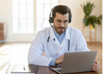 doctor wearing head phones looking at laptop