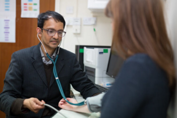 GP taking a patients blood pressure