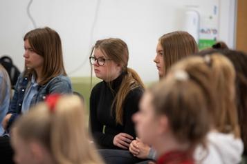 Group of young people sitting listening