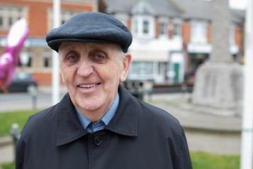 Older man facing front smiling at camera