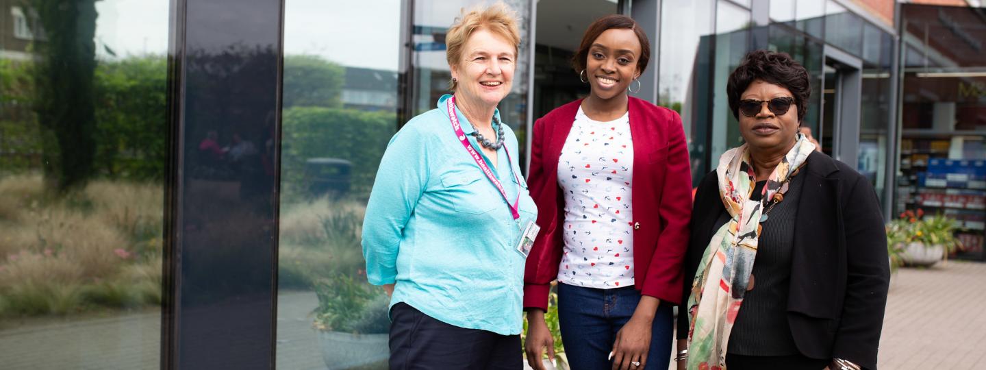 Three women outside hospital entrance