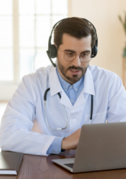 doctor wearing head phones looking at laptop