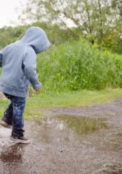 child splashing in puddles