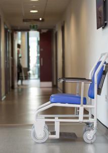 Empty wheel chair against a wall in hospital corridor